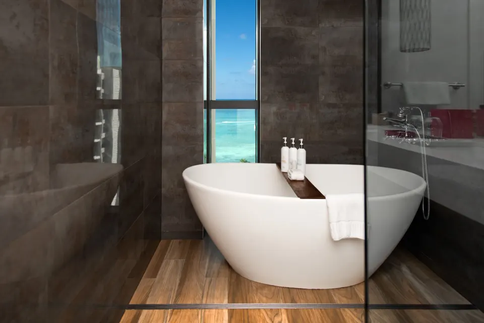 Freestanding bathtub with narrow ocean view window in studio bathroom at Kimpton Seafire Resort + Spa