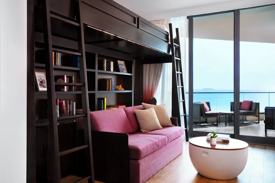 Bunk loft and pink sofa in a Premium Ocean View One-Bedroom Family Suite at Kimpton Seafire Resort + Spa
