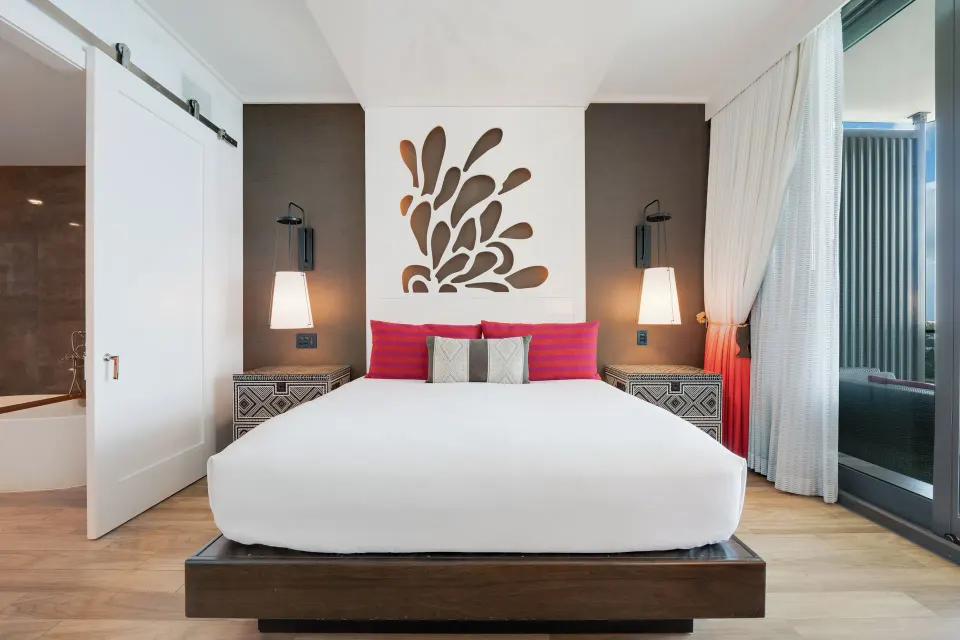 King bed with decorative headboard in a Premium Ocean View One-Bedroom Family Suite at Kimpton Seafire Resort + Spa