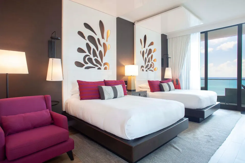 Two queen beds and seating area in a Premium Ocean View Queen Room at Kimpton Seafire Resort + Spa