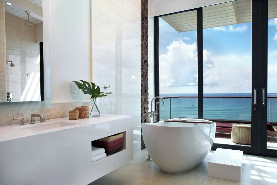 Bathroom with freestanding tub and ocean view through sliding glass doors in a Presidential Oceanfront Two‑Bedroom Suite at K