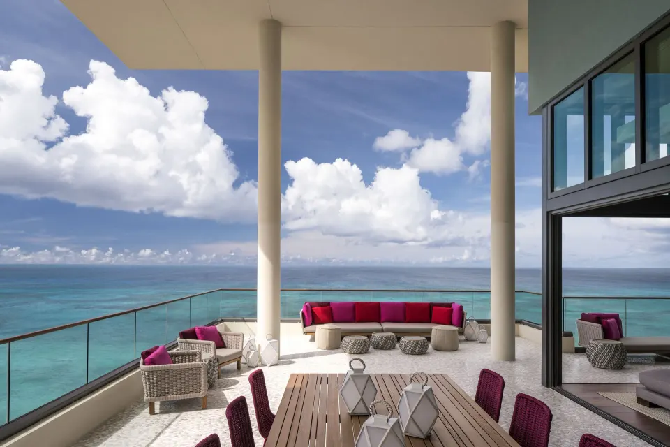 Expansive oceanfront private terrace with dining table and seating at Kimpton Seafire Resort + Spa