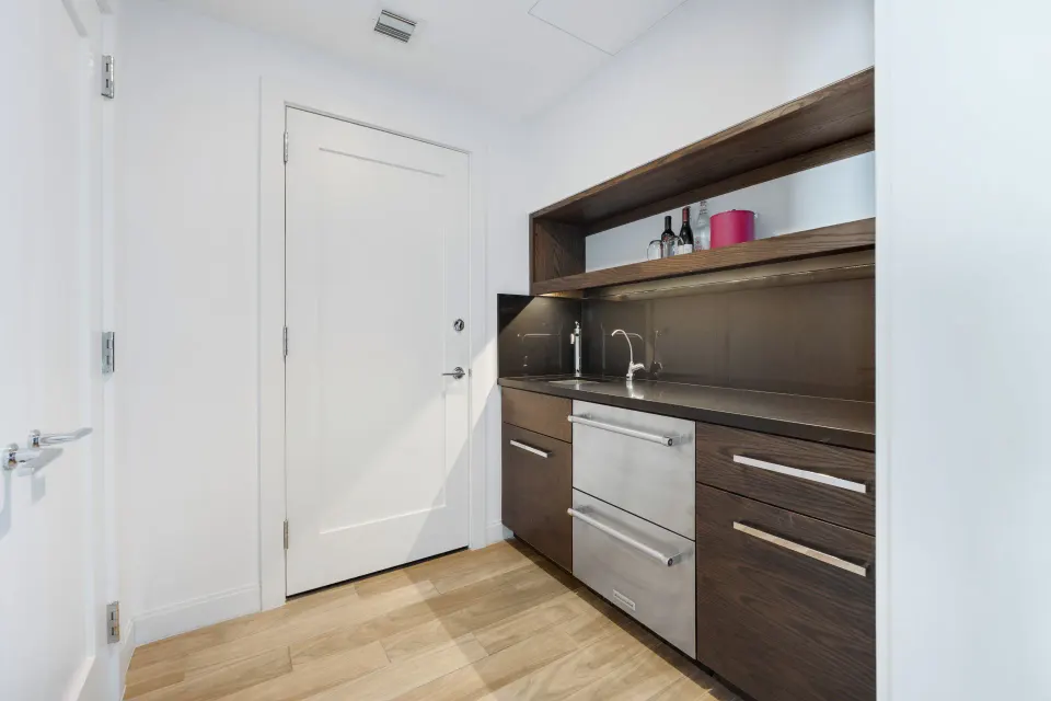 Angle view of the kitchenette and entry door in Yacht Club View King Room at Kimpton Seafire Resort + Spa
