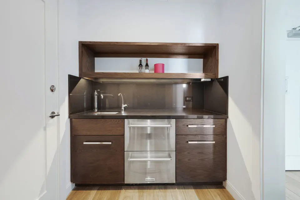 Dark wood wet bar and compact kitchenette in Yacht Club View King Room at Kimpton Seafire Resort + Spa