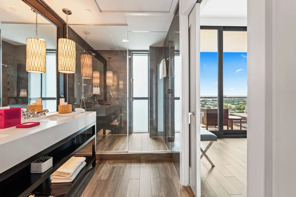 Bathroom and shower leading to guest room balcony in Yacht Club View King at Kimpton Seafire Resort + Spa