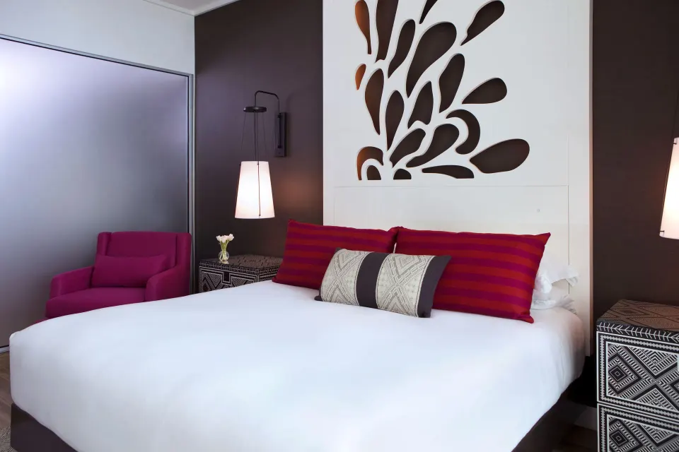 Front-facing king bed with decorative headboard in a Yacht Club View King Room at Kimpton Seafire Resort + Spa