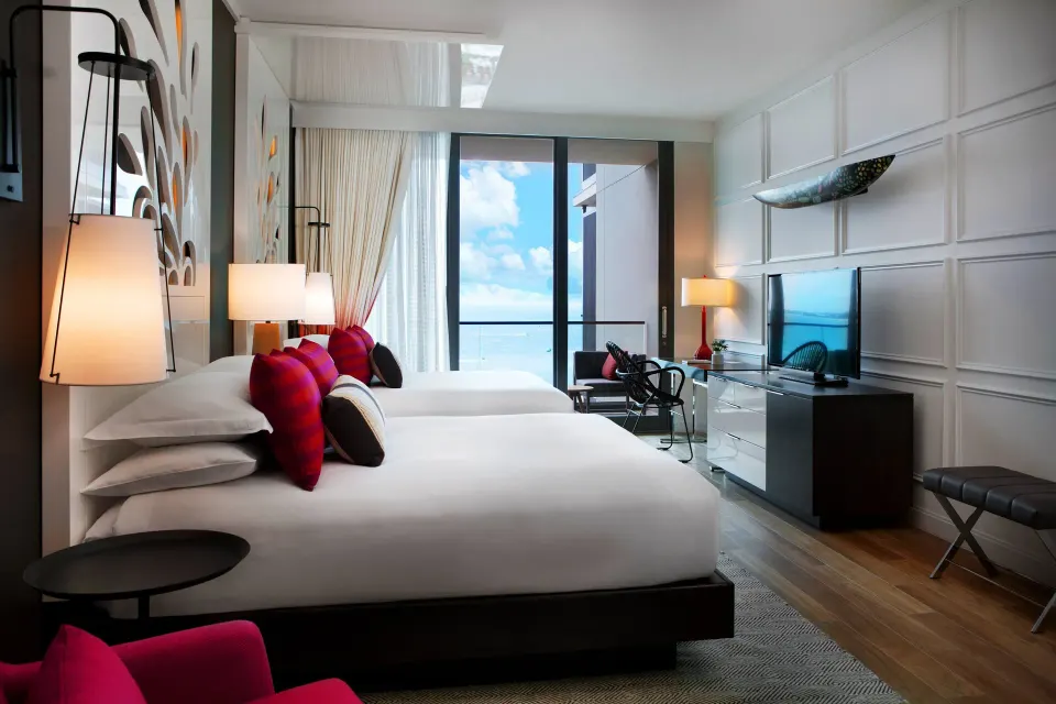 Yacht Club View Queen Room with balcony, seating area and decorative wall panels at Kimpton Seafire Resort + Spa