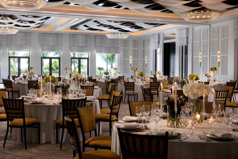 Ballroom set for a formal reception with round tables and floral centerpieces at Kimpton Seafire Resort + Spa