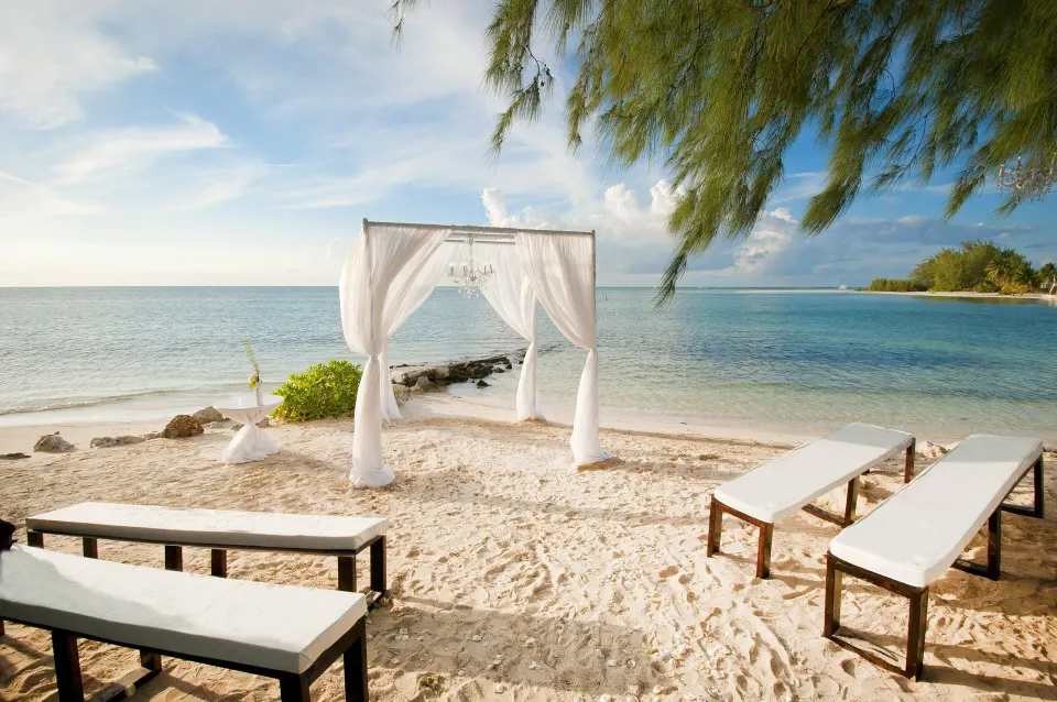Beach wedding canopy and benches on sand at Kimpton Seafire Resort + Spa