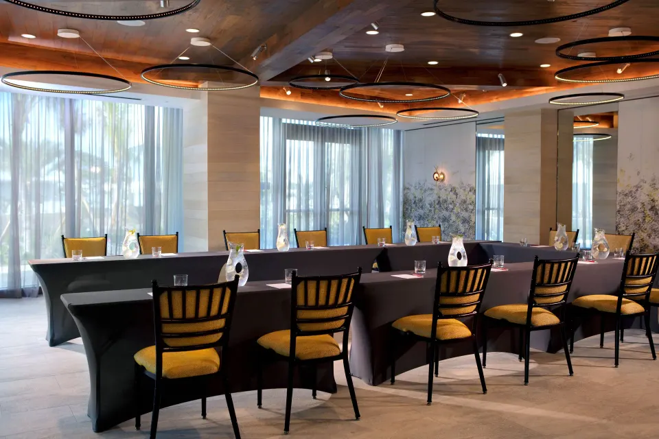 Meeting room with rows of tables and yellow chairs at Kimpton Seafire Resort + Spa