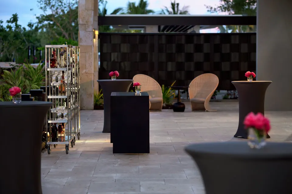Outdoor cocktail setup with high-top tables and lounge seating at Kimpton Seafire Resort + Spa