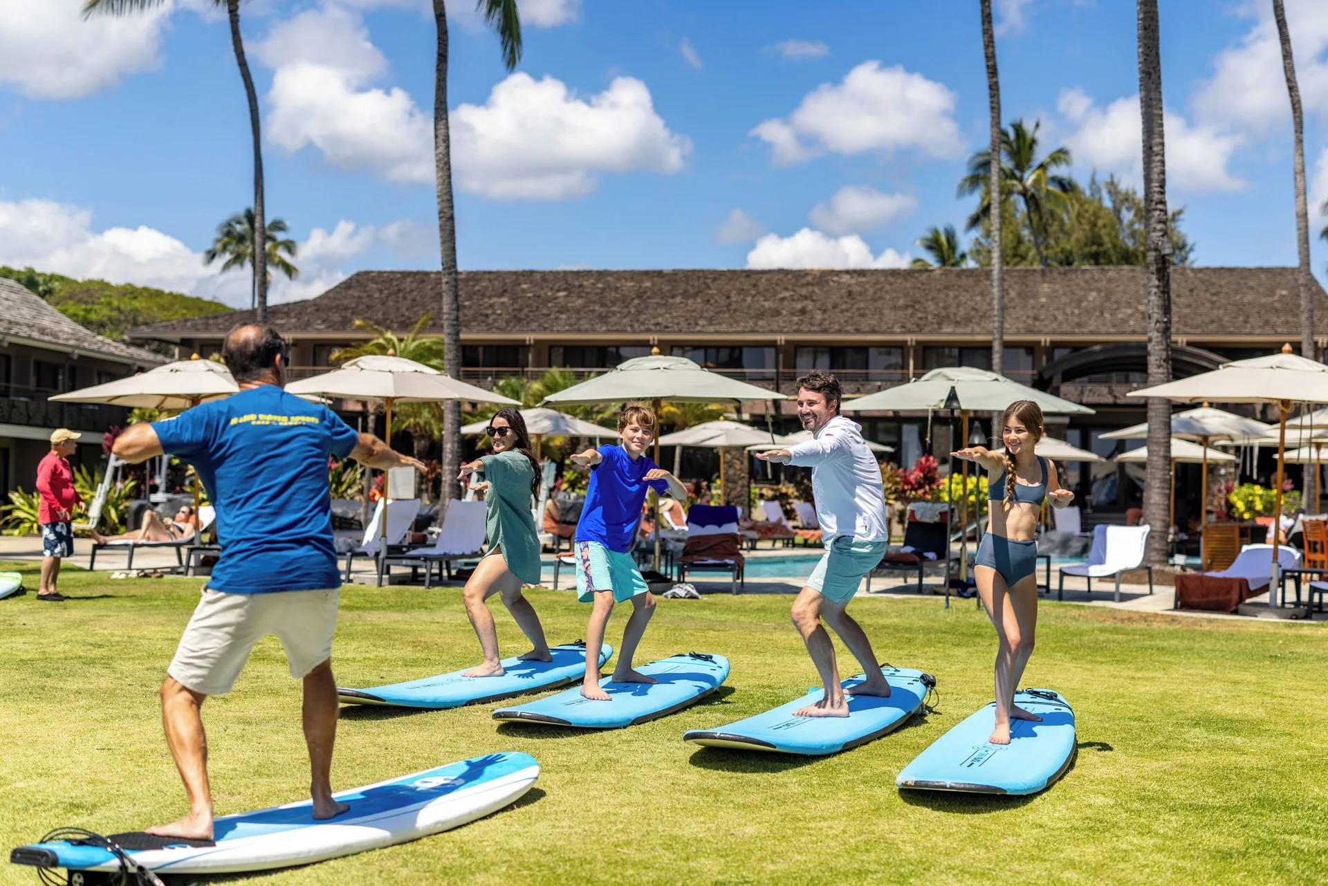 Guests balance on surfboards during a lawn activity at Ko'a Kea Resort on Po'ipu Beach.
