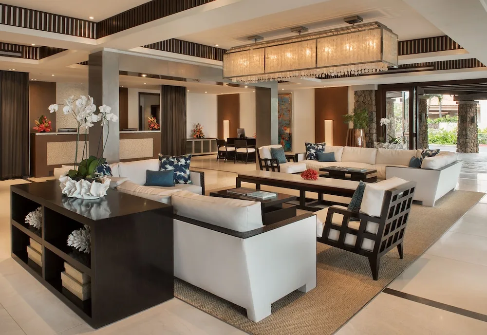 Lobby lounge with sofas, reception desks, and floral decor at Ko'a Kea Resort on Po'ipu Beach.