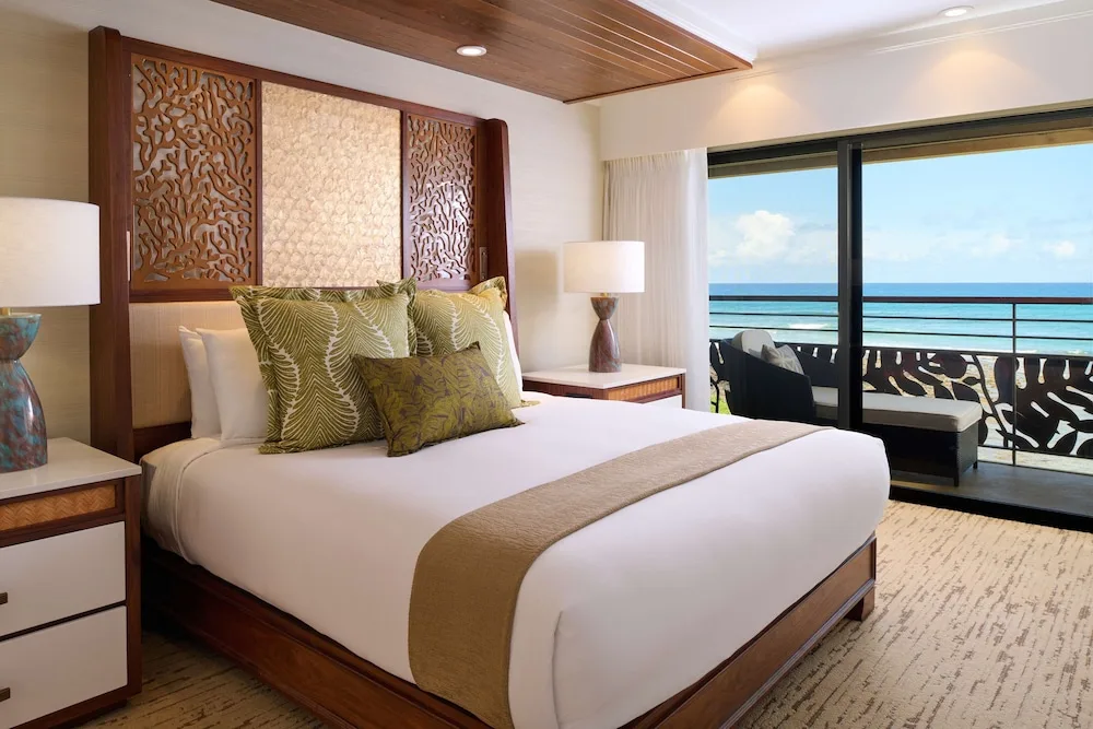 Ocean-view king guest room with balcony seating at Ko'a Kea Resort on Po'ipu Beach.