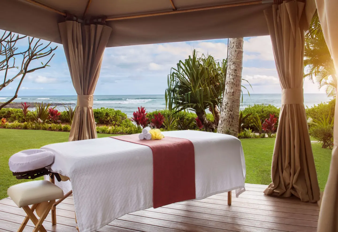 Outdoor massage table at Ko'a Kea Resort on Po'ipu Beach under a cabana facing the ocean.