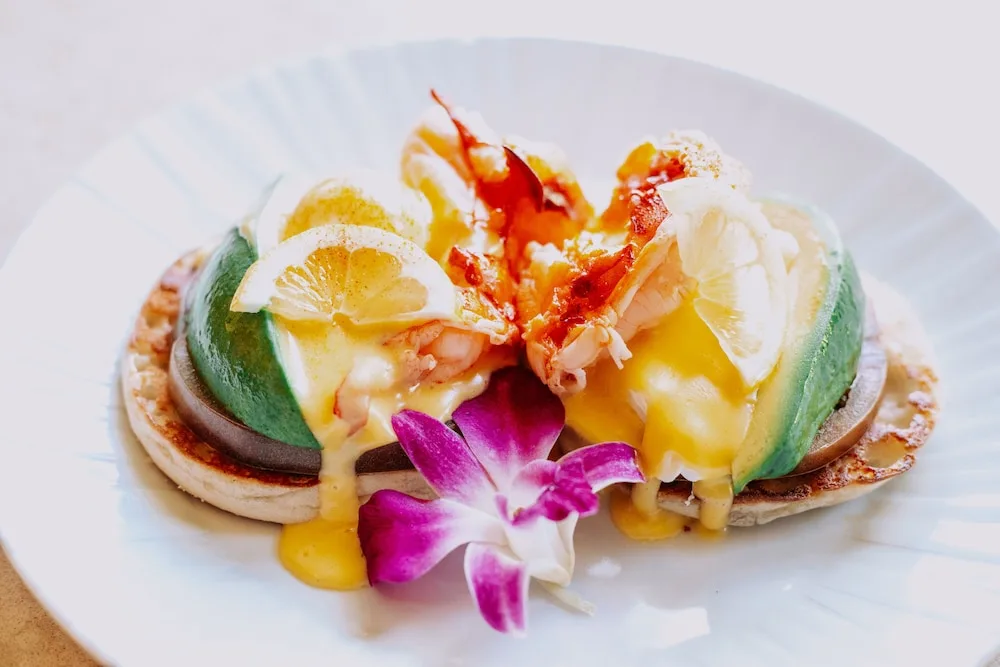 Seafood breakfast dish with poached eggs and orchid garnish at Ko'a Kea Resort on Po'ipu Beach.