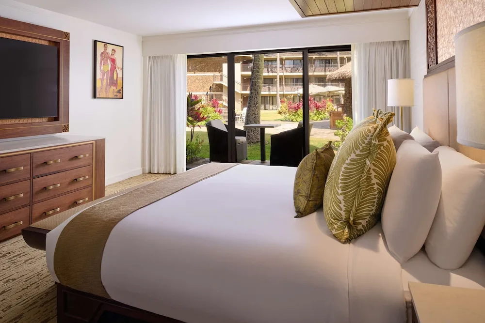 Garden View king bed facing sliding patio doors at Ko'a Kea Resort on Po'ipu Beach.