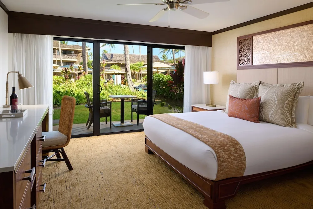 Garden View king room with sliding doors to the patio at Ko'a Kea Resort on Po'ipu Beach.