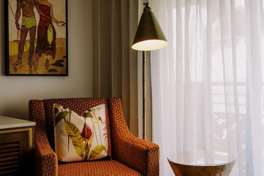Garden View room sitting area with armchair and floor lamp at Ko'a Kea Resort on Po'ipu Beach.