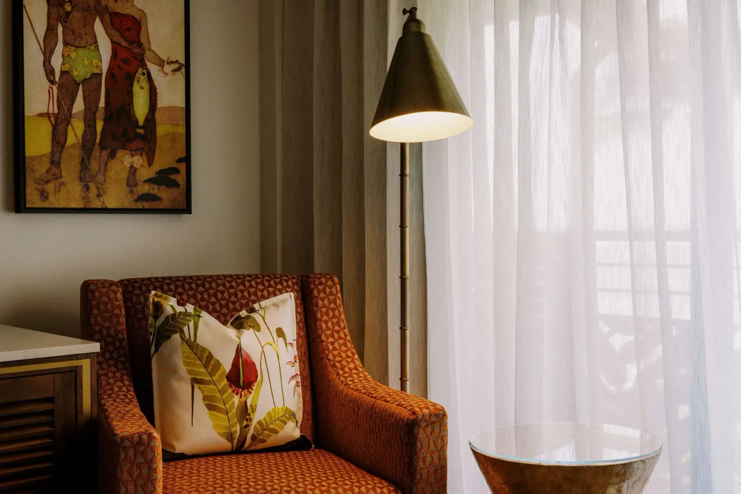 Upholstered chair, floor lamp, and sheer curtains in a room at Ko'a Kea Resort on Po'ipu Beach.