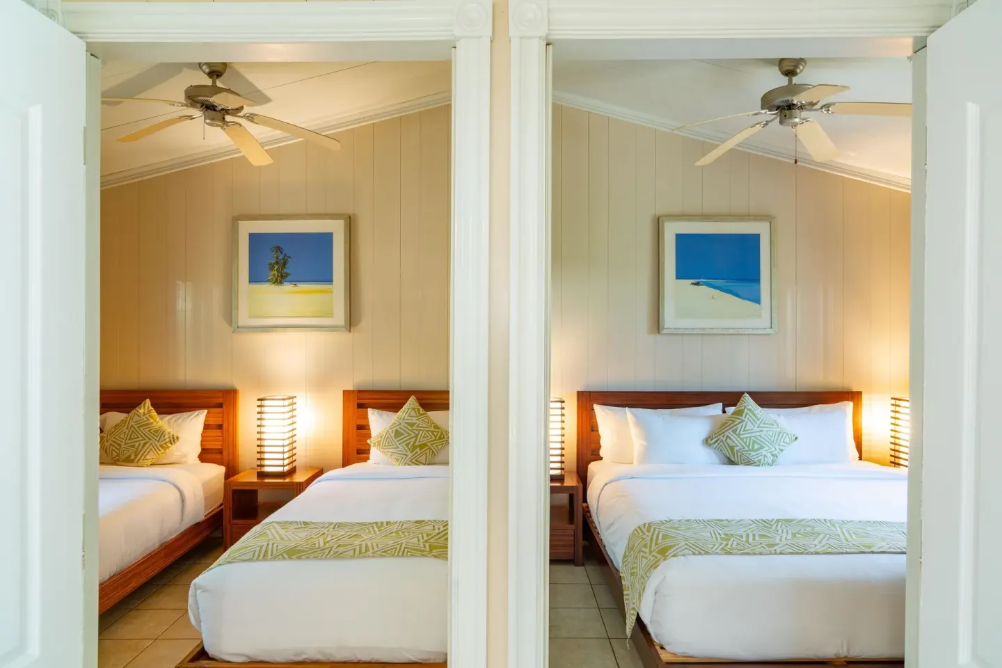 Two adjoining bedrooms with twin beds and a larger bed at Kokomo Botanical Resort.