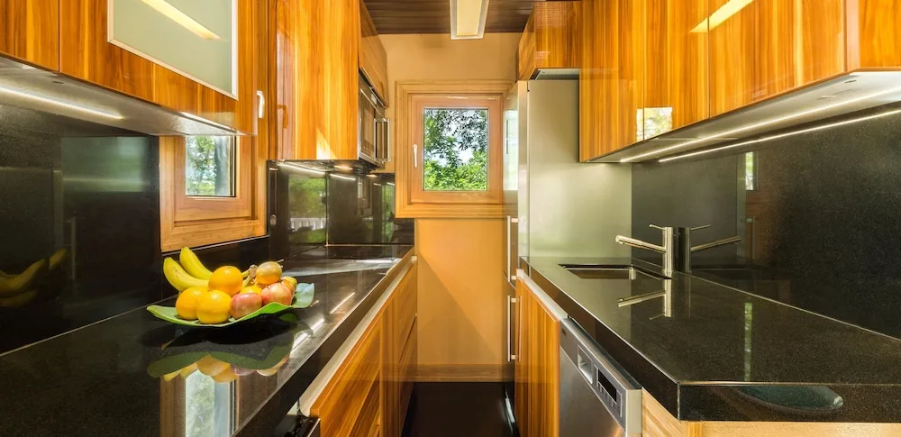 Modern galley kitchen with glossy black counters at Kokomo Botanical Resort.