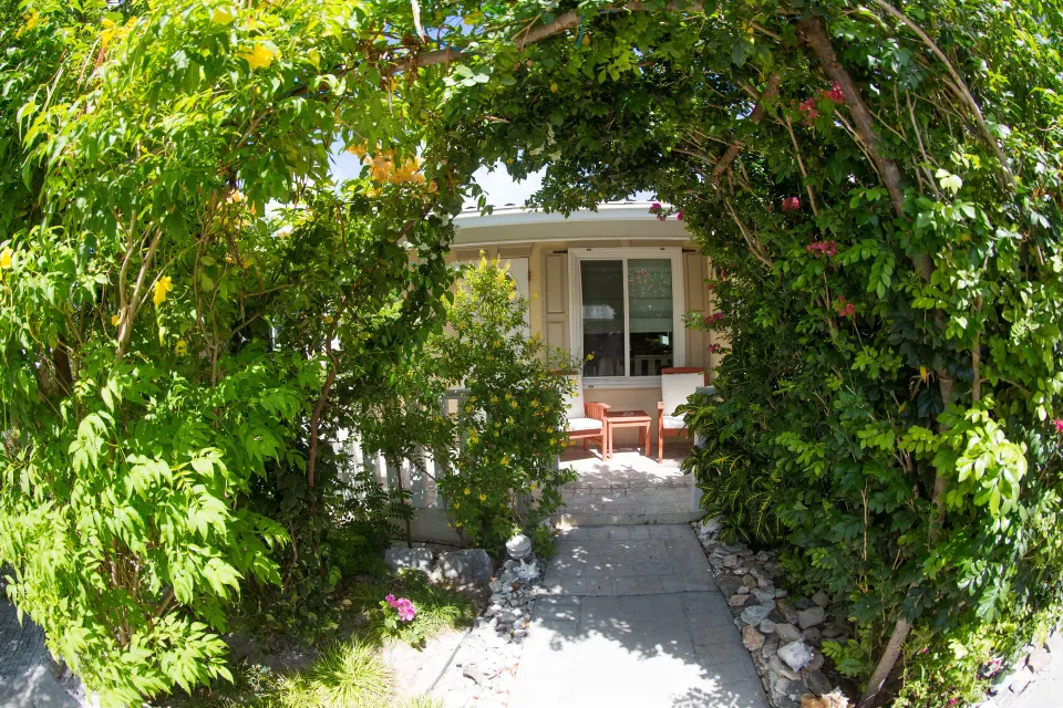 Leafy garden archway frames a cottage entrance at Kokomo Botanical Resort.