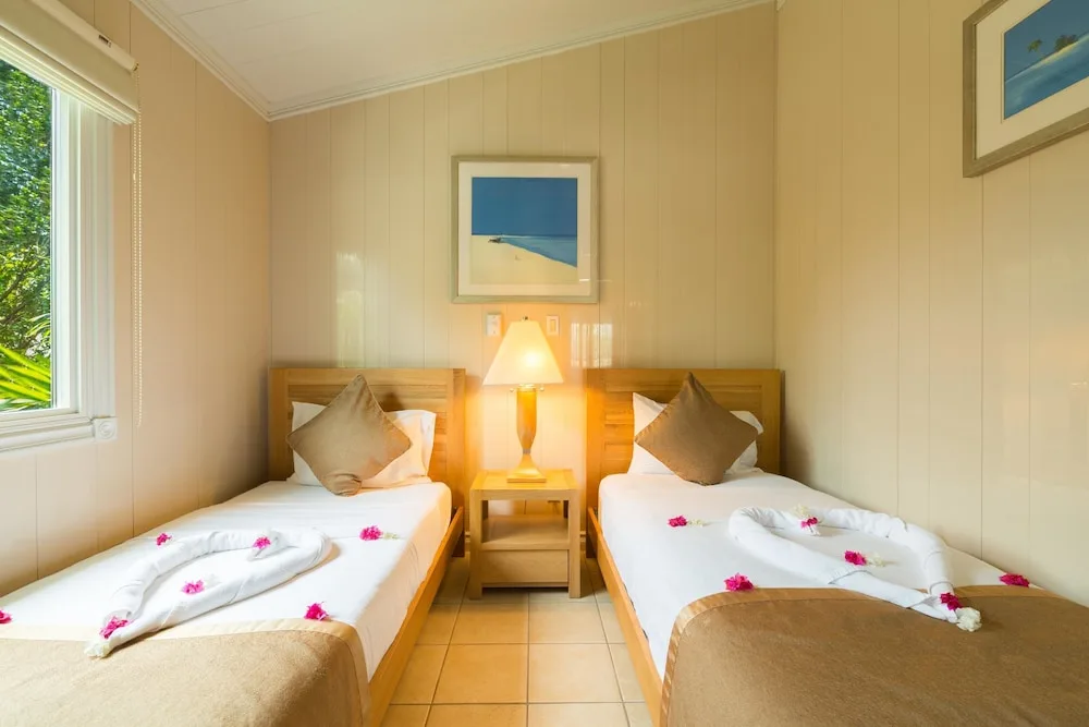 Twin beds with towel decorations and flower petals at Kokomo Botanical Resort.