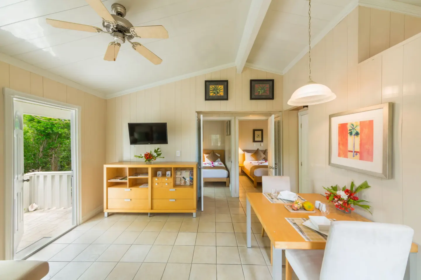 Suite dining area with open patio door and bedroom visible at Kokomo Botanical Resort.