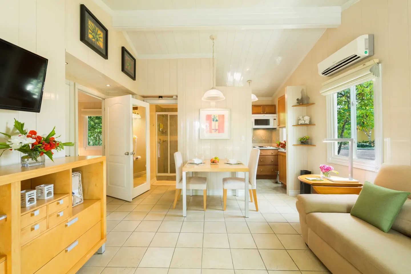 Bright suite living area with dining table and kitchenette at Kokomo Botanical Resort.