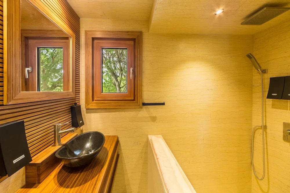 Wood-accent bathroom with black vessel sink at Kokomo Botanical Resort.