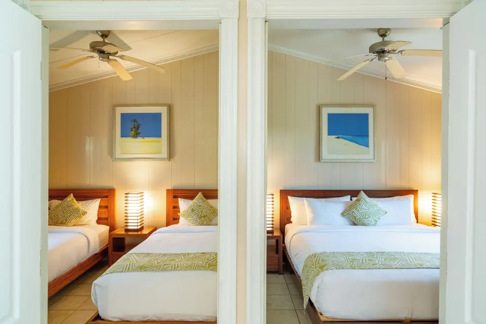 Two adjoining bedrooms with queen beds in a Deluxe Cottage at Kokomo Botanical Resort.
