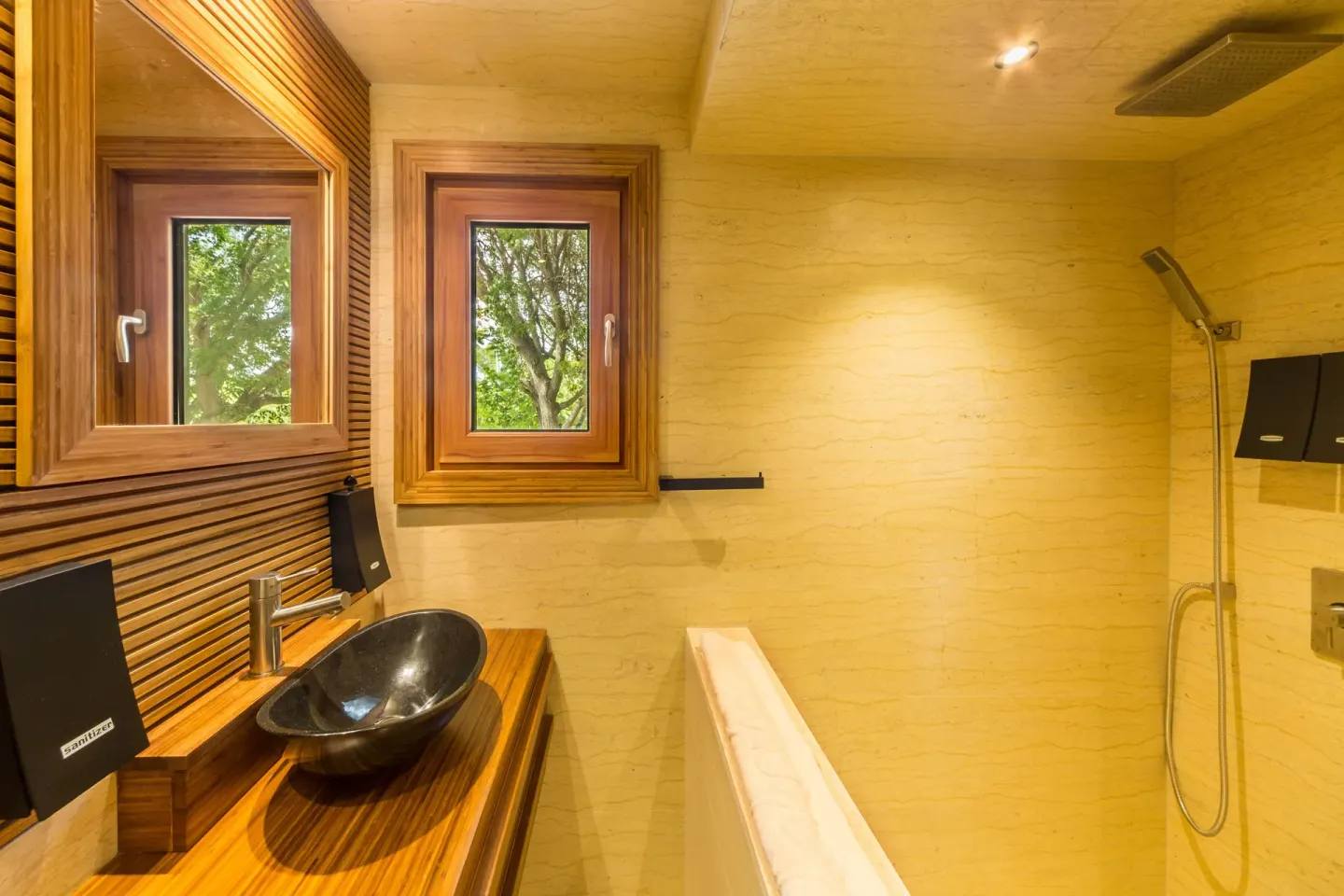 Superior Cottage bathroom at Kokomo Botanical Resort with vessel sink, tub, shower, and wood-framed window.