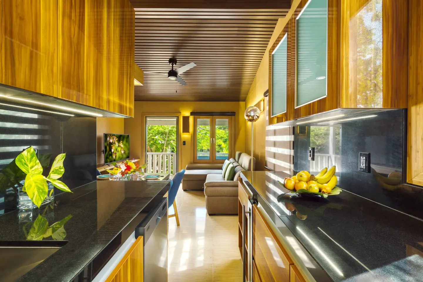 Superior Cottage galley kitchen leading to sofa and balcony at Kokomo Botanical Resort.