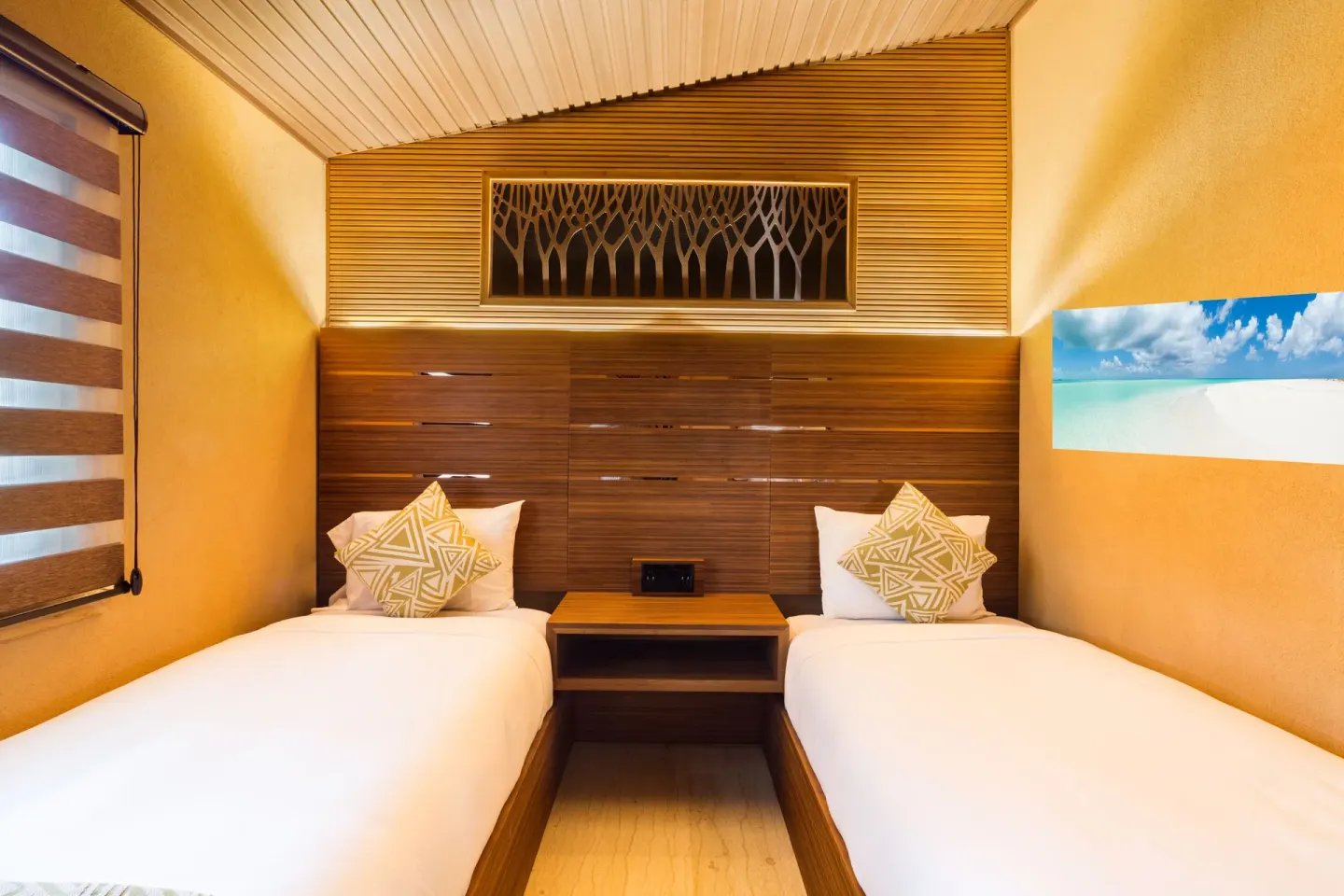 Twin bedroom in a Superior Cottage at Kokomo Botanical Resort with wood headboard and warm lighting.