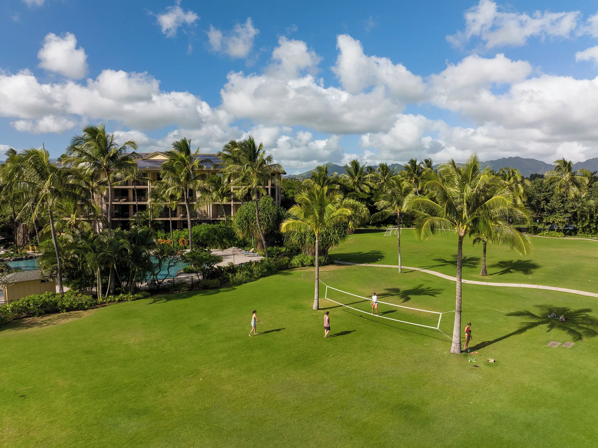 Palm-lined lawn and volleyball net at Koloa Landing Resort at Poipu.