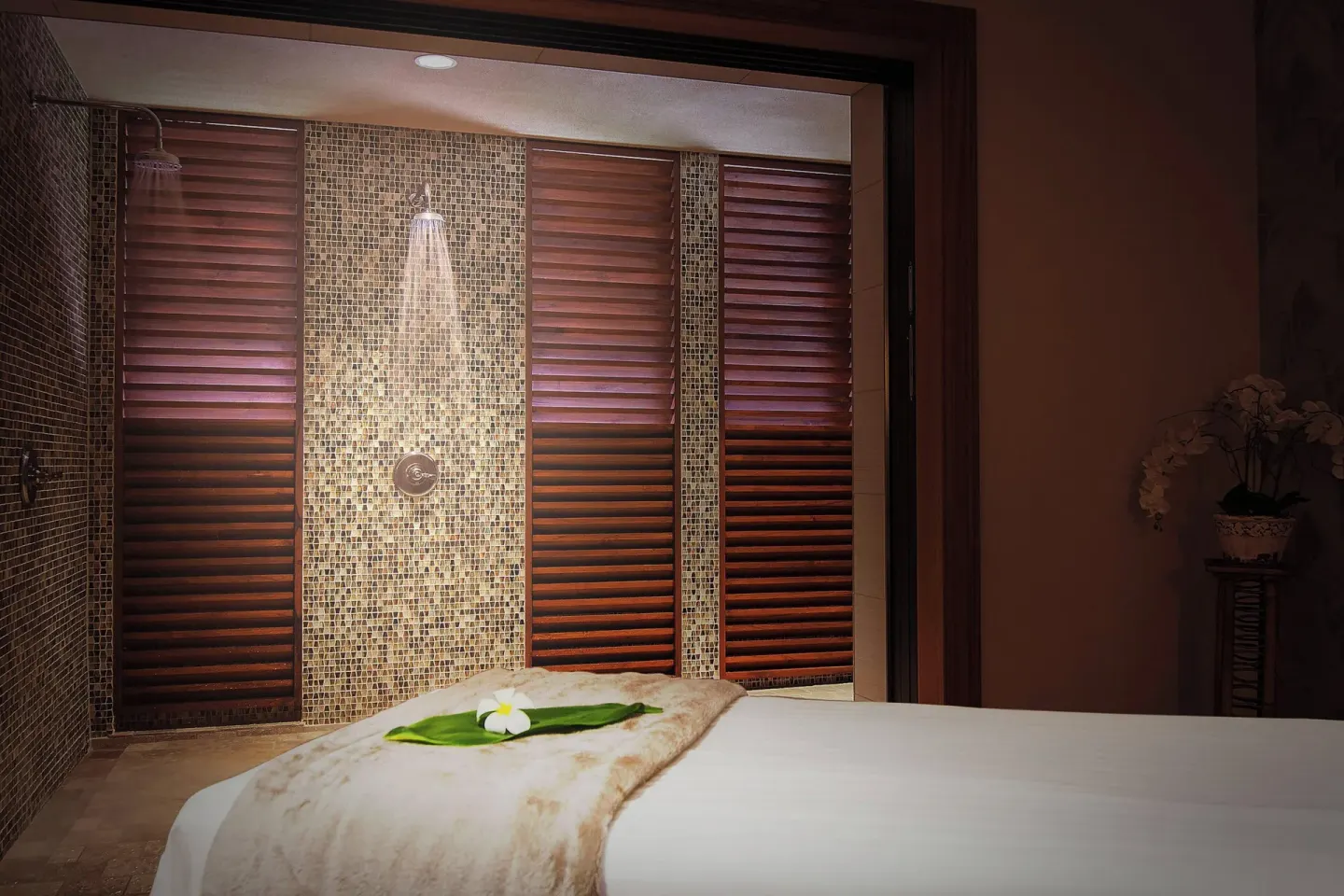 Spa treatment room with massage table and tiled shower area at Koloa Landing Resort at Poipu.