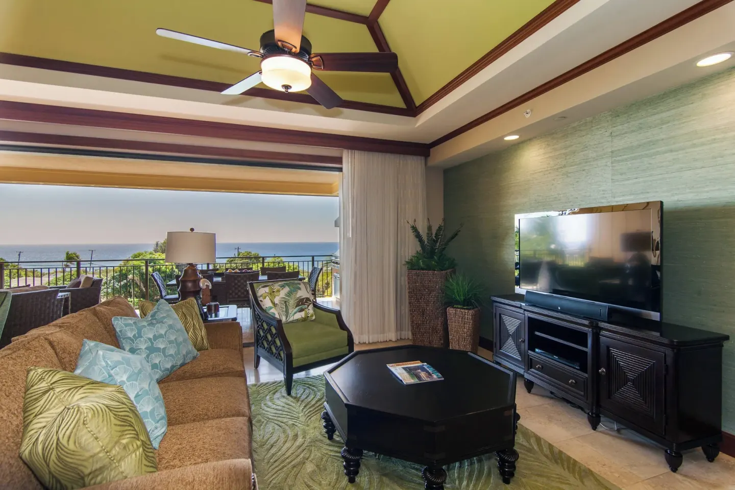 Living room with sofa, television, and ocean balcony at Koloa Landing Resort at Poipu.