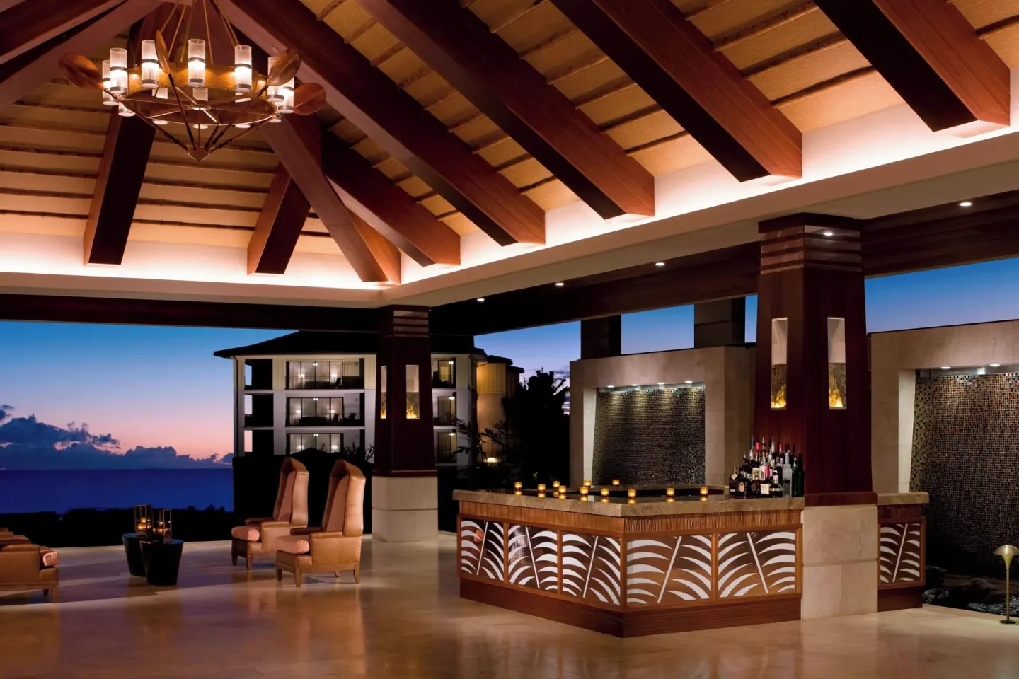 Open-air bar and lounge area at Koloa Landing Resort at Poipu at dusk.