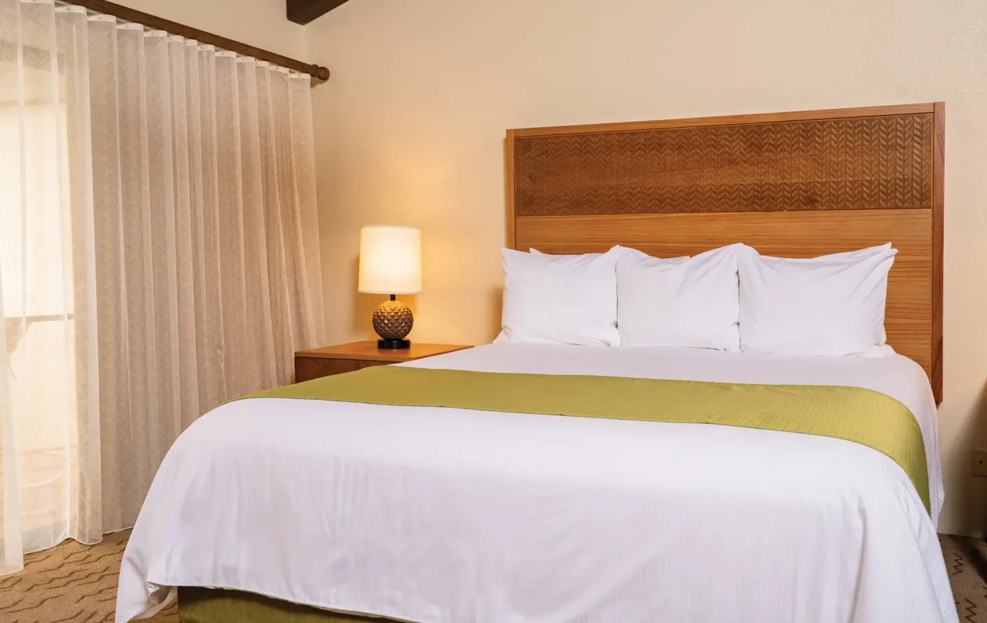 One Bedroom Villa Honu king bed with green runner at Kona Coast Resort.