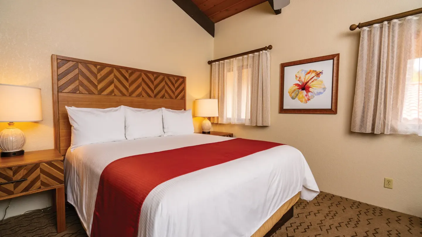 One Bedroom Villa Honu king bedroom with hibiscus artwork at Kona Coast Resort.