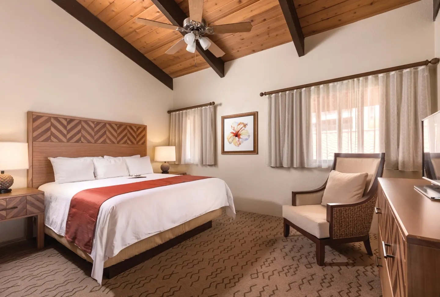 One Bedroom Villa Honu king bedroom with chair and dresser at Kona Coast Resort.
