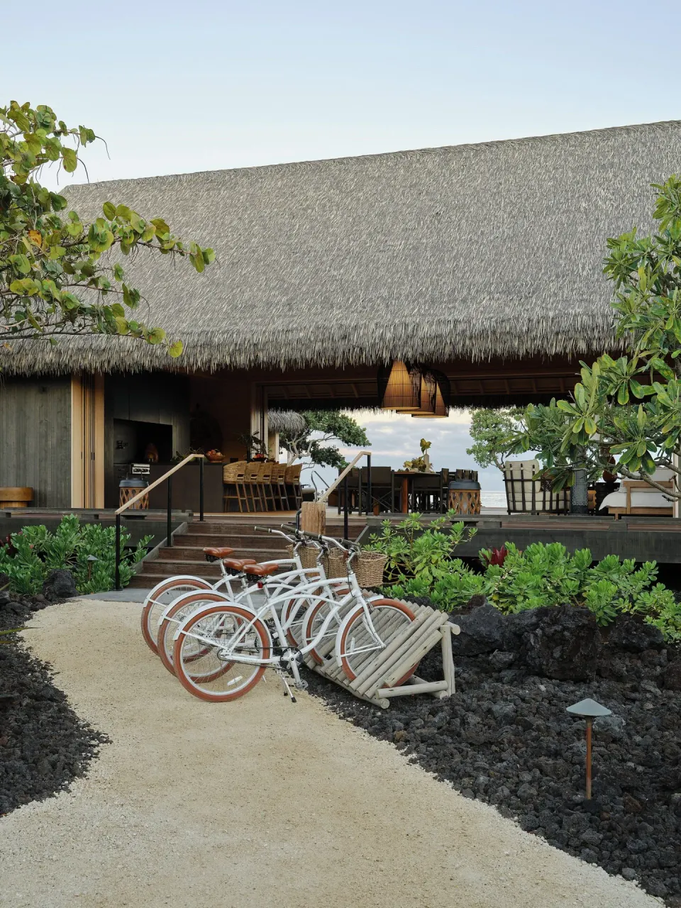 White bicycles parked by a thatched open-air building at Kona Village.