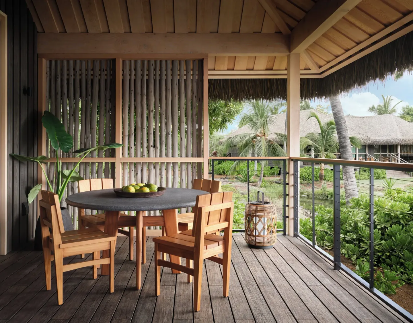 Covered lanai with wooden dining set and garden views at Kona Village.