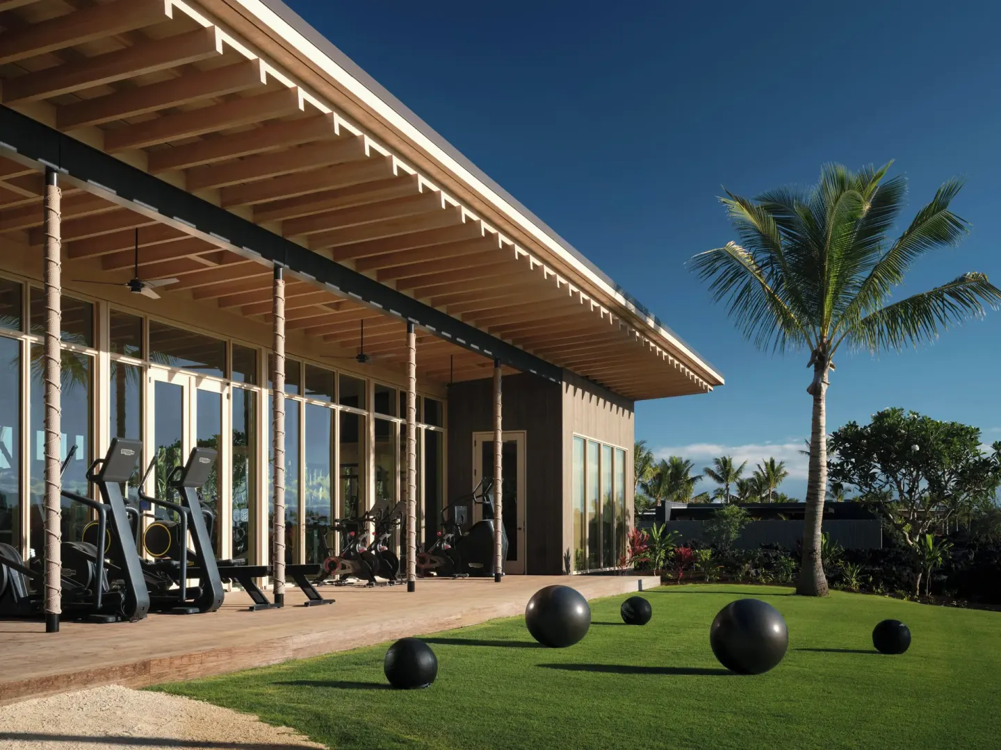 Exterior of the fitness center with exercise equipment and lawn at Kona Village.