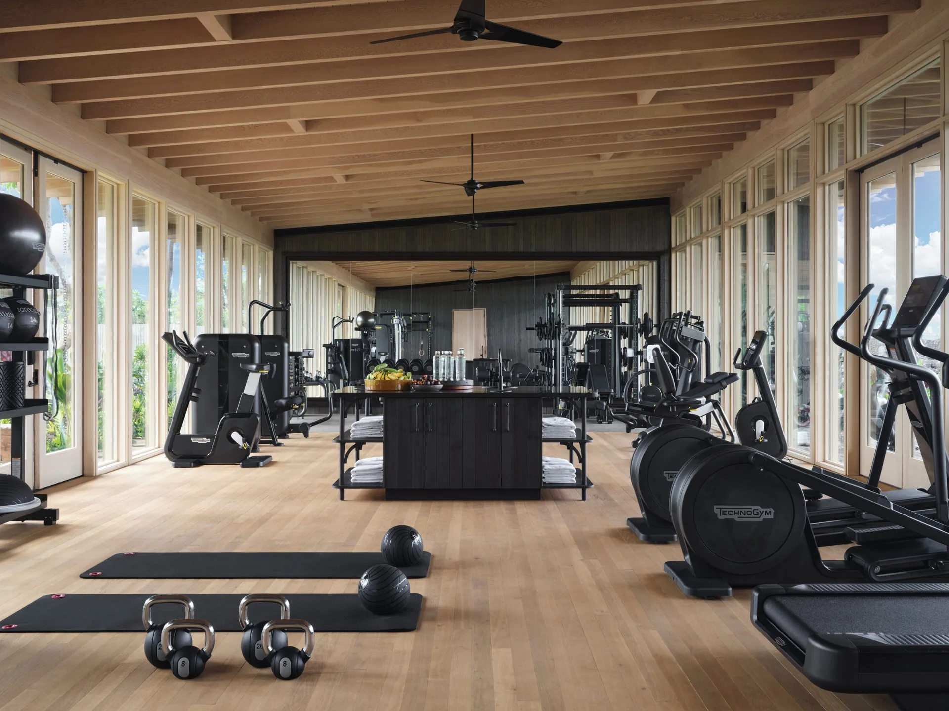 Fitness studio with mats, kettlebells, cardio machines, and mirrors at Kona Village.
