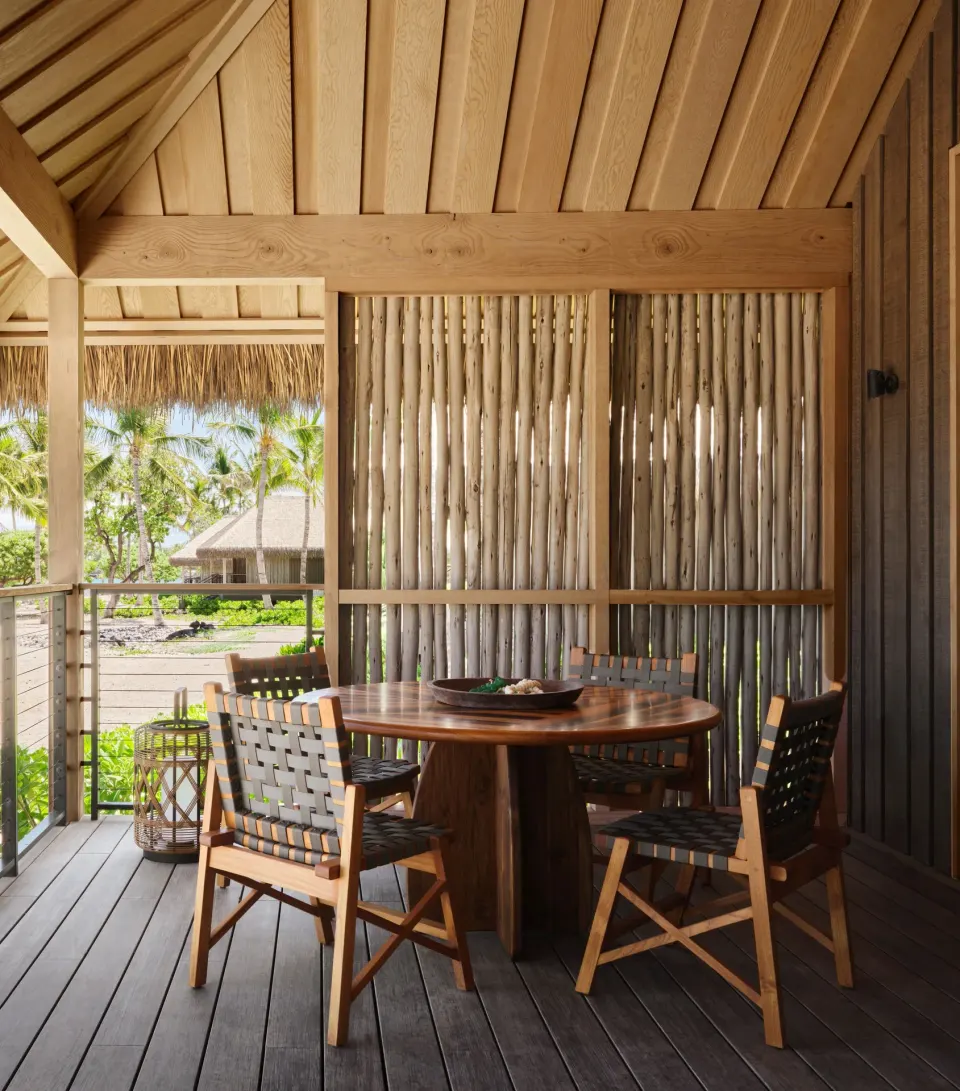 Close view of a lanai dining table and wood screen at Kona Village.