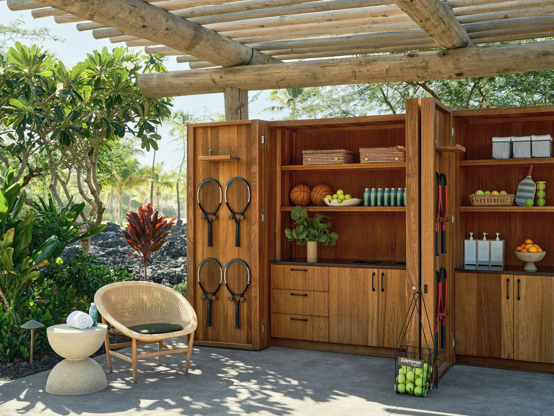 Outdoor sports cabinet with tennis rackets, balls, towels, and fruit at Kona Village.