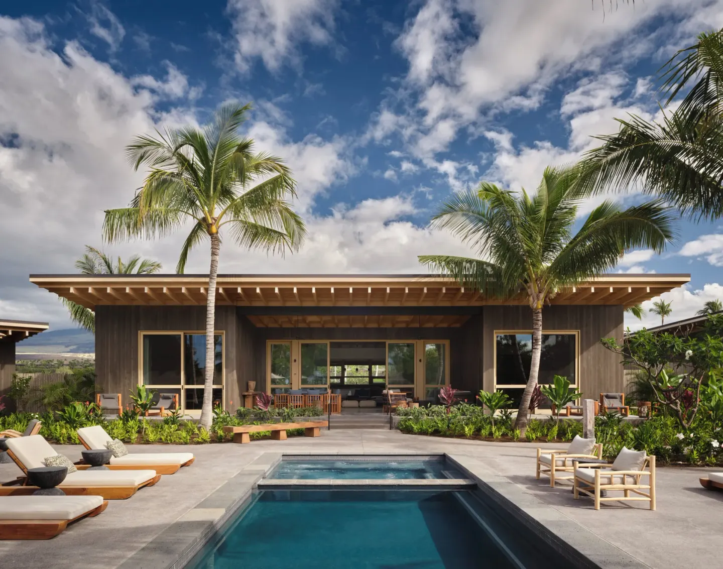 Private pool terrace with loungers and palm trees at Kona Village.