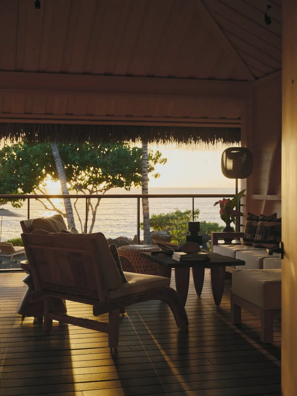 Guest room lanai lounge seating silhouetted at sunset at Kona Village.